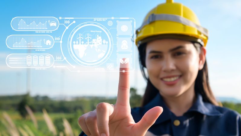 Symbolfoto: Eine Frau mit Arbeitskleidung bedient ein Touchpad mit Symbolen aus dem Bereich Energie.